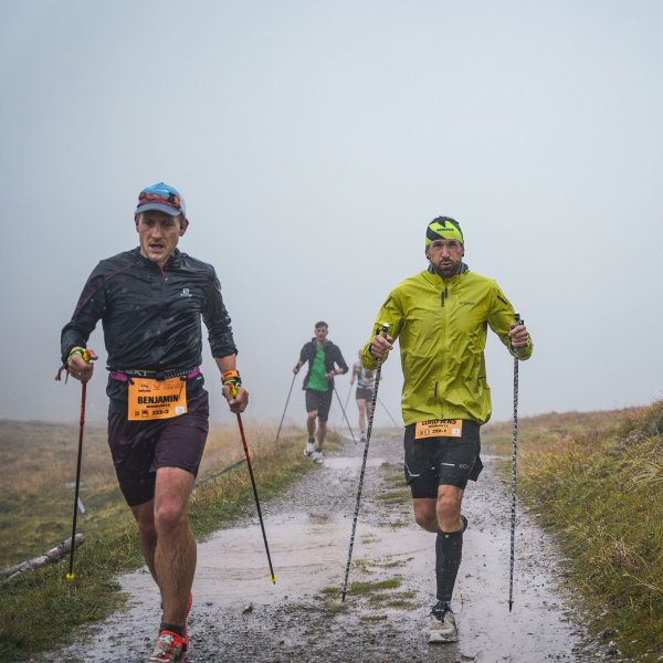 2025-transalpin-jens-kramer-mit-laufpartner-im-regen-auf-dem-trail