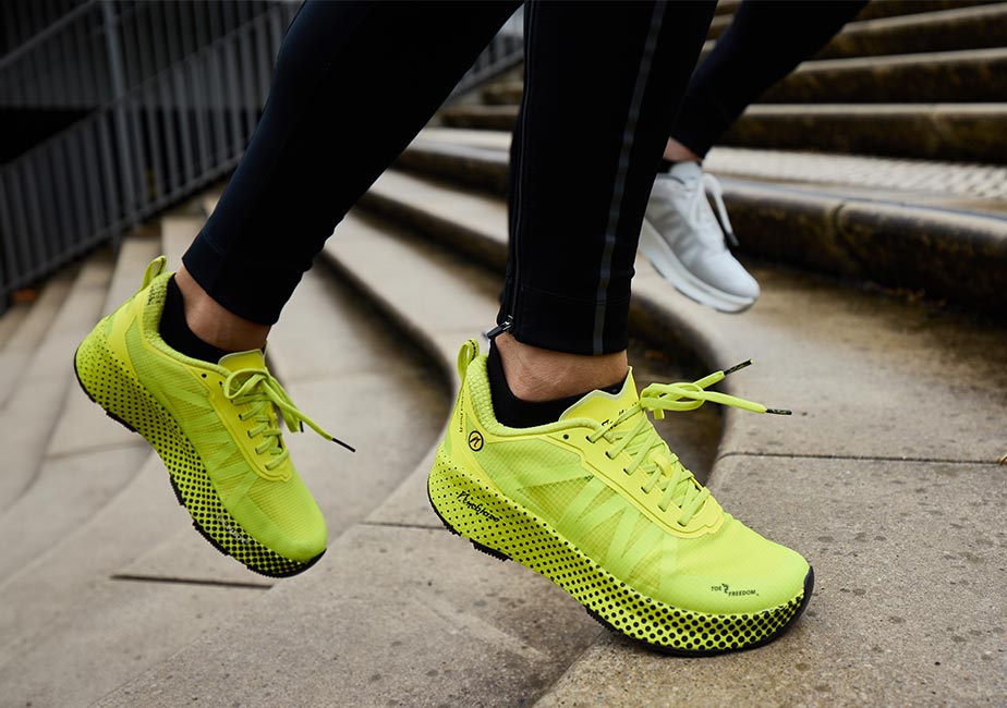 Der Joe Nimble Addict Pro-R Laufschuh in Gelb im Lauftraining auf der Treppe