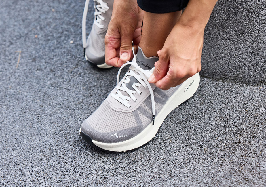 Läufer bindet seinen Joe Nimble Addict Pro-R in grau